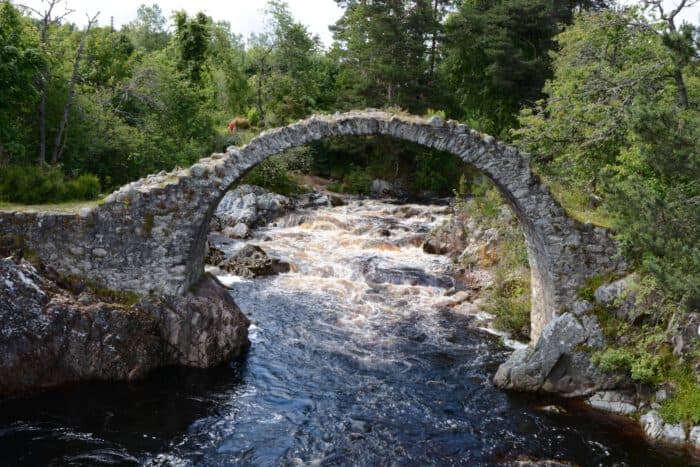 Photo of remains of humpback rubble filled Packhorse Bridge (built 1717) at Carrbridge, Scotland